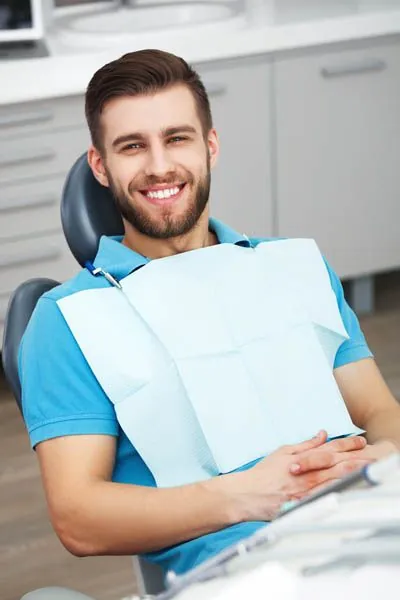 man smiling during his follow up after a tooth extraction at Corson Dentistry
